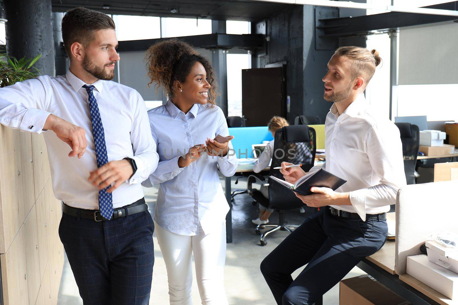 Group of young business people discussing something while working in the creative office.