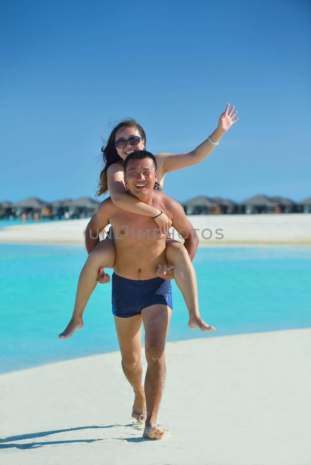 happy young  couple enjoying summer on beach by dotshock