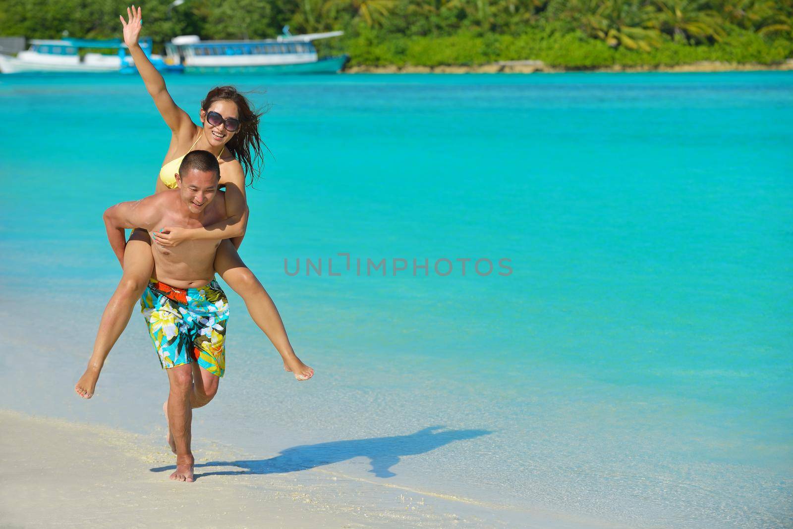 happy young  couple enjoying summer on beach by dotshock