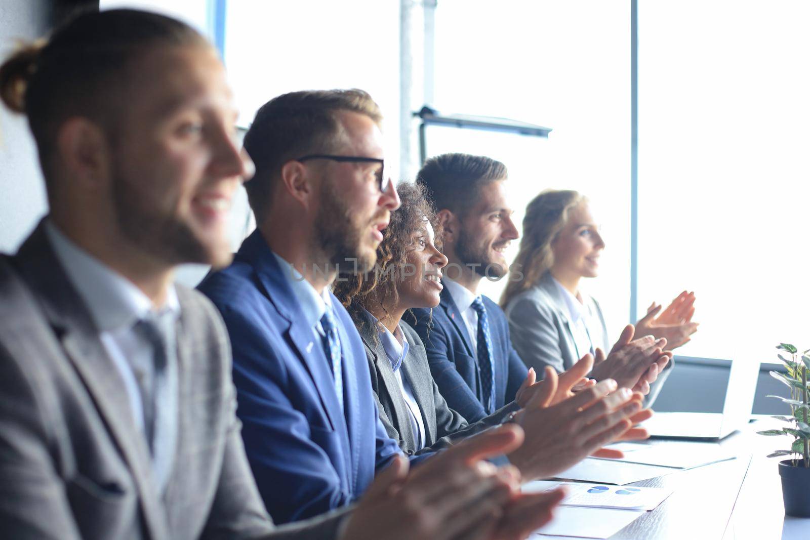 Photo of happy business people applauding at conference