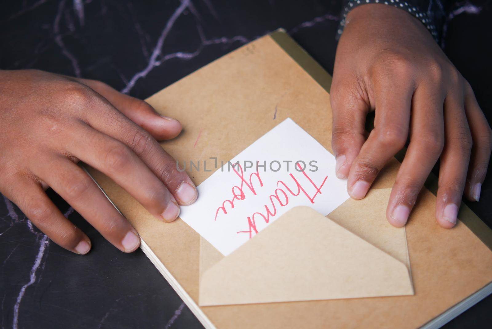 close up of man hand reading a thank you letter .