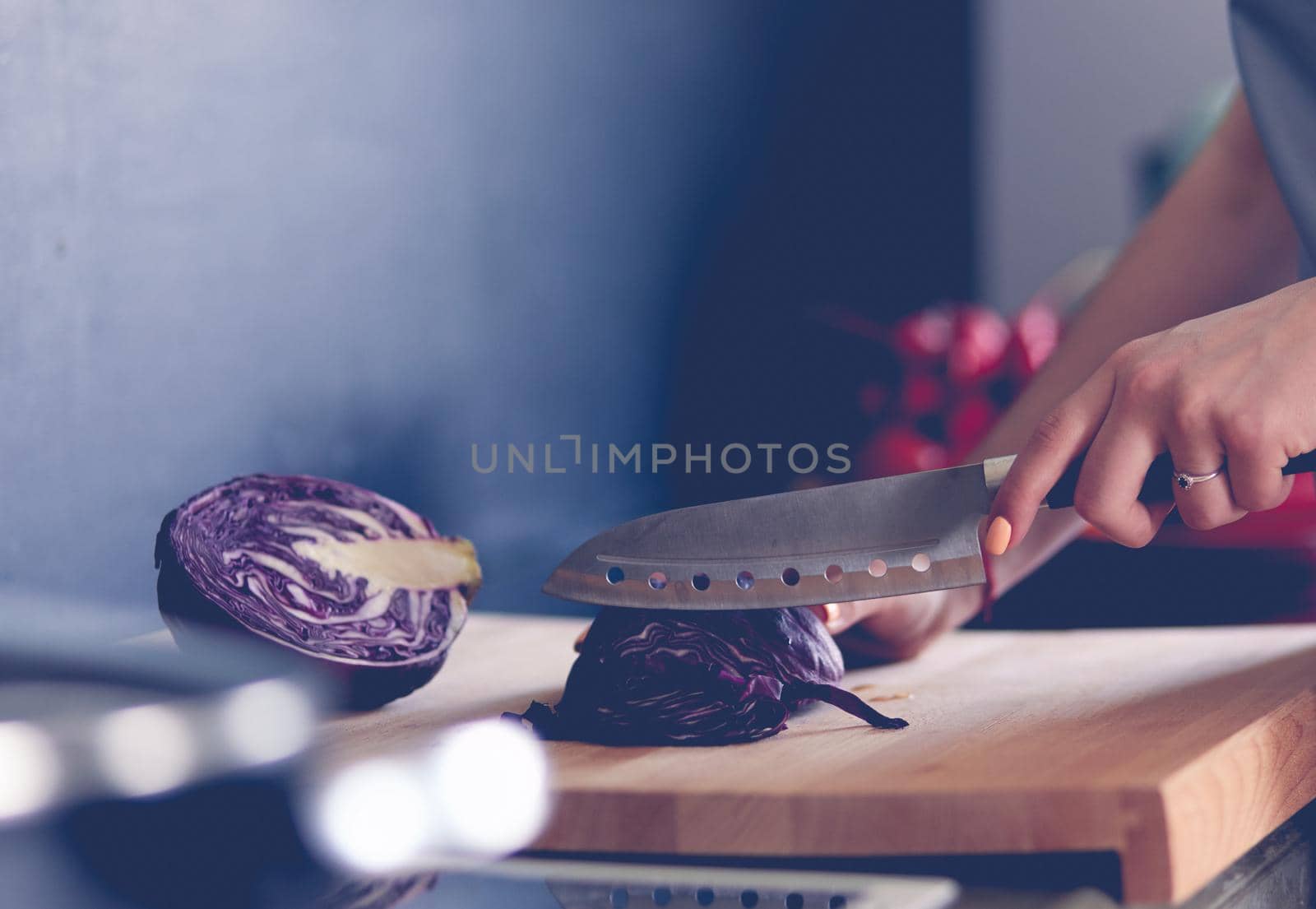 Woman cooking in new kitchen making healthy food with vegetables.