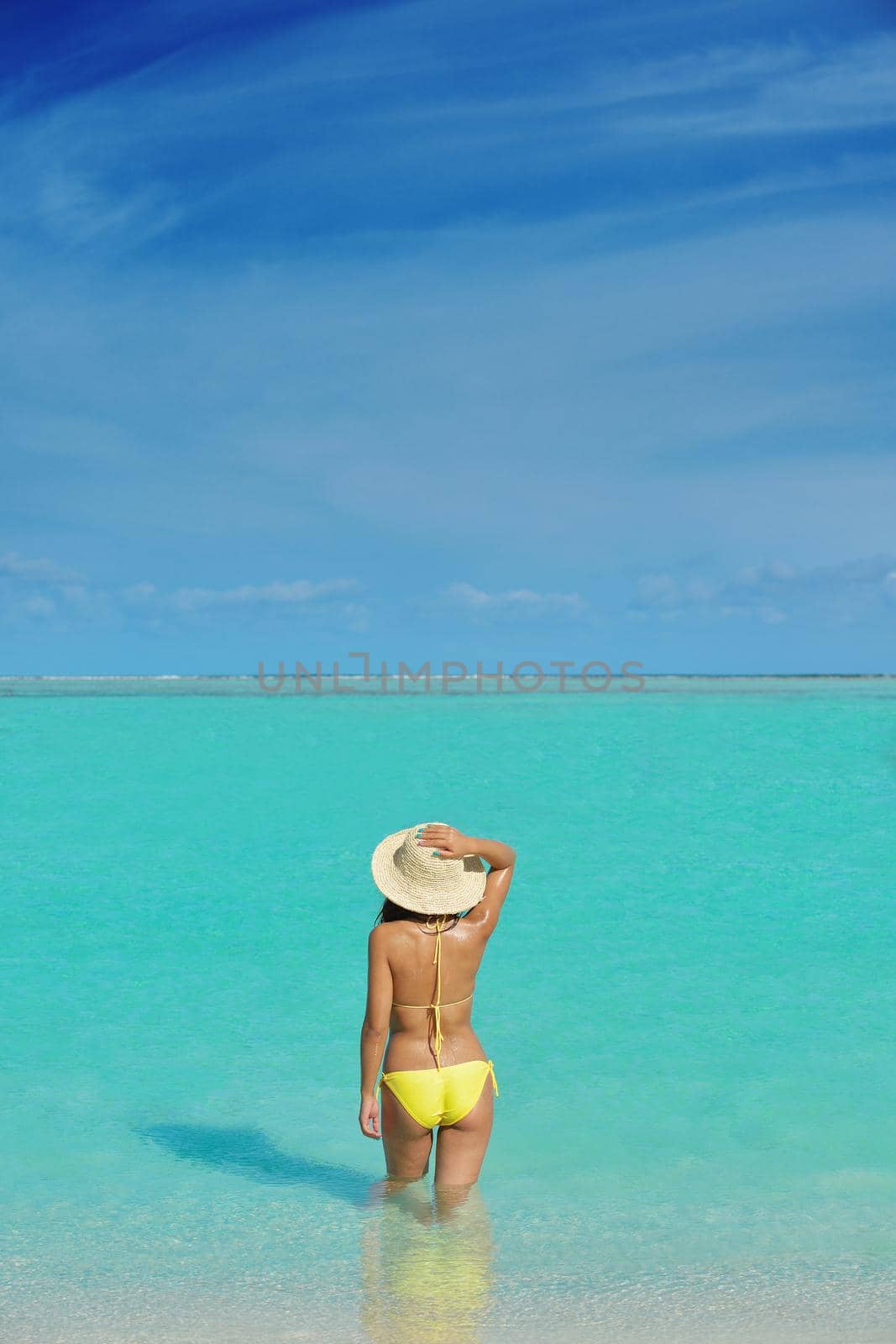 happy young pretty asian woman resting on sand at tropical beach