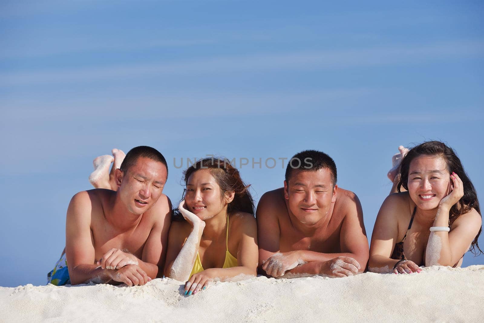 group of happy young people have fun and joy at the  white sand  beach on beautiful summer  day