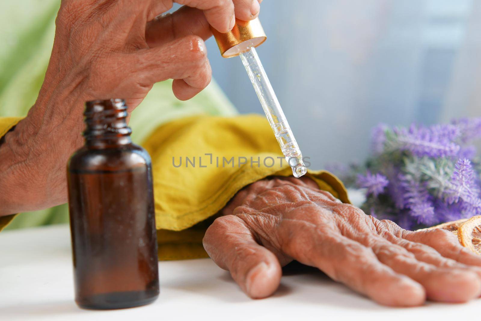 senior women applying essential oils on hand ,