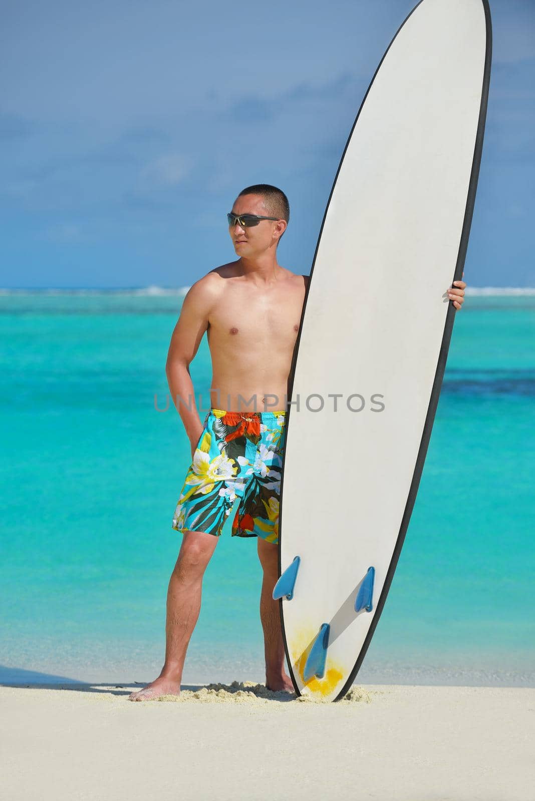 Man with surf board on beach by dotshock