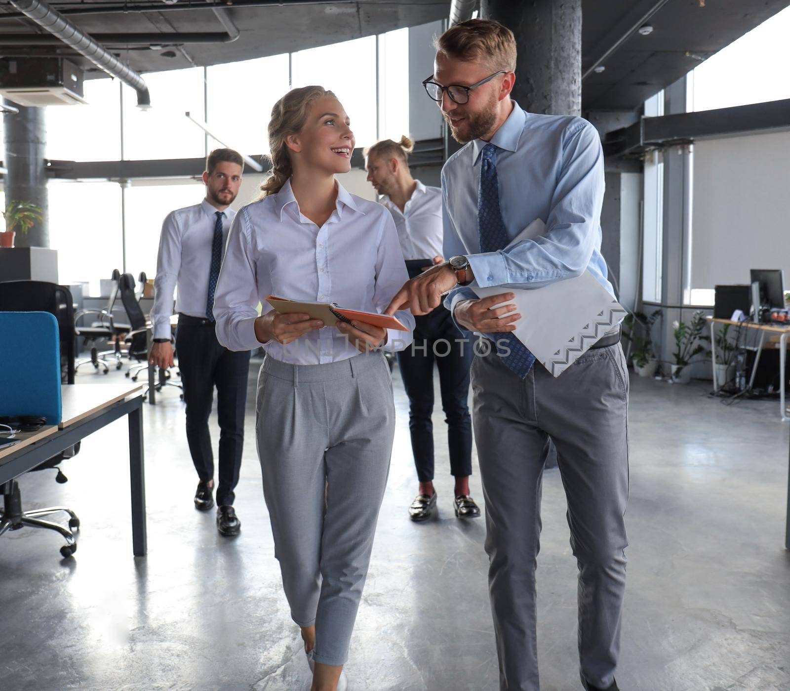 Modern business people have a discussion while walking through the office.
