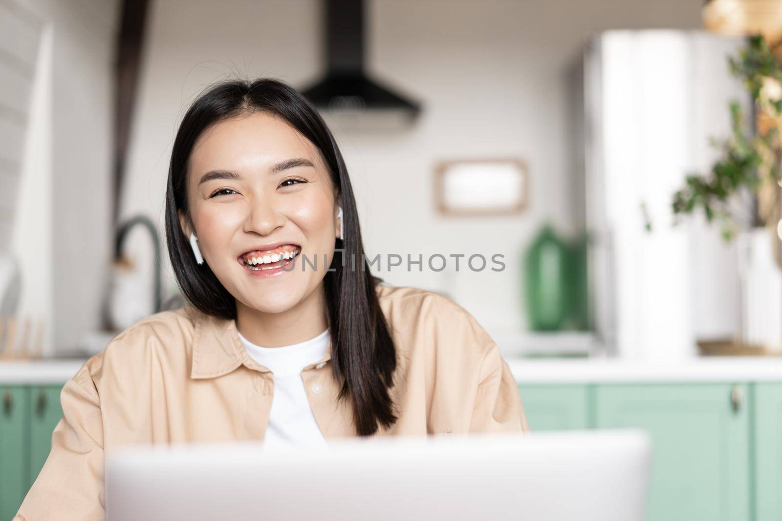 Happy asian girl laughing, working on laptop from home. Young woman resting with computer.