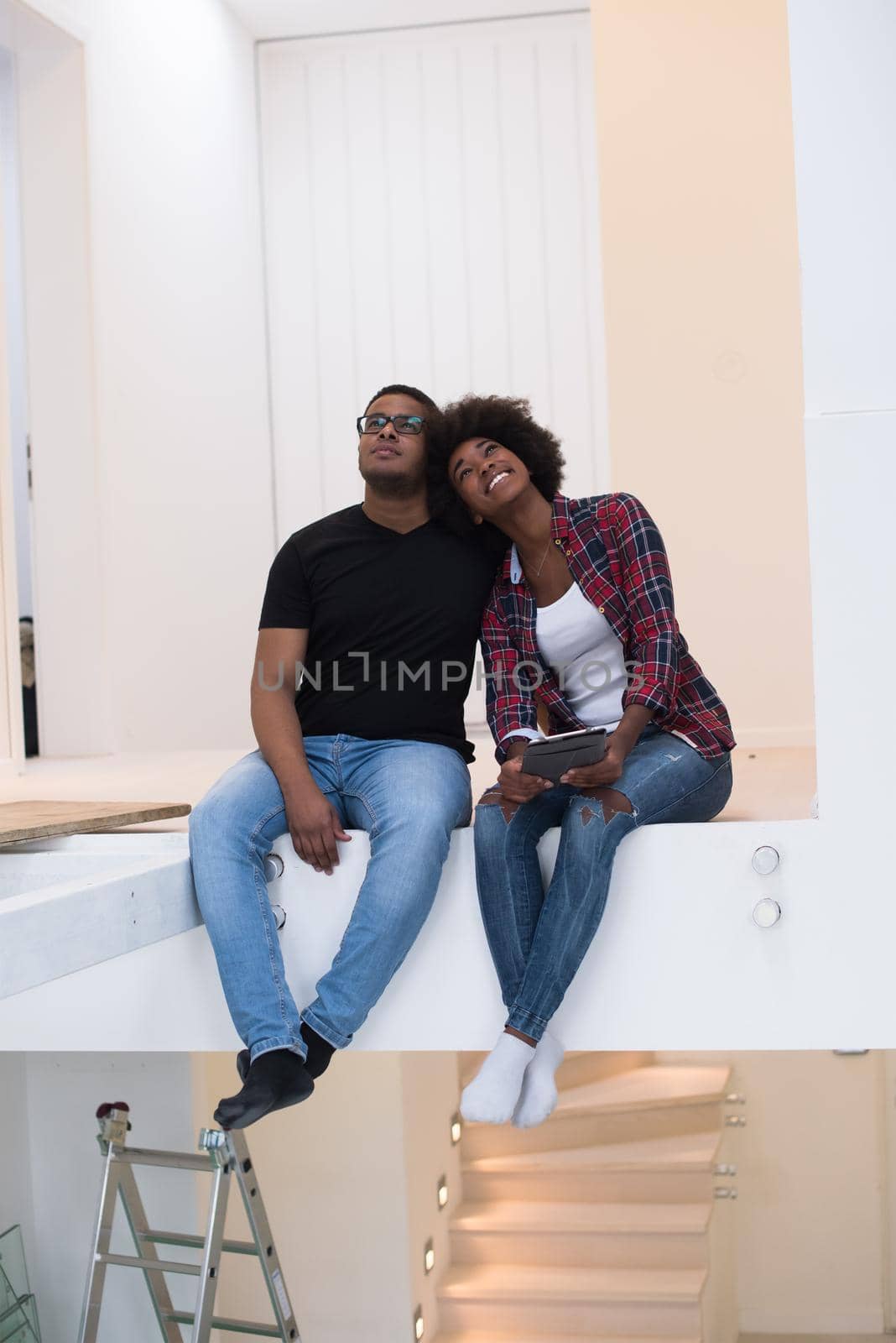 Happy young African American couple having break during moving to new house