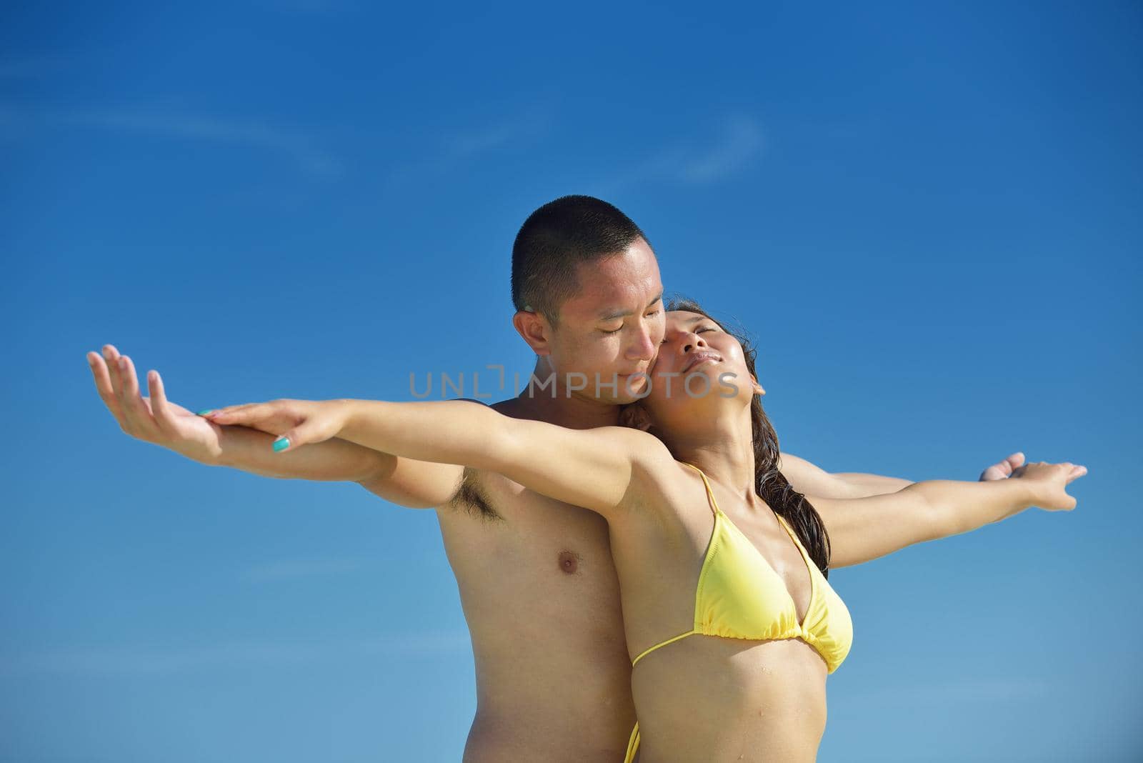 happy young  couple enjoying summer on beach by dotshock