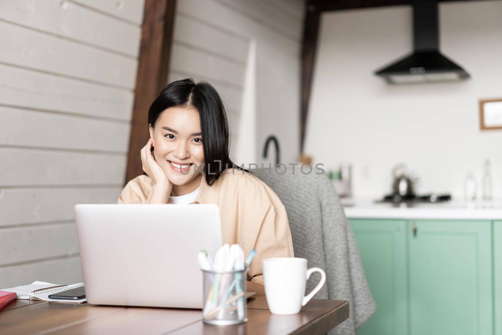 Smiling girl student, asian woman working with laptop at home, studying at home by Benzoix