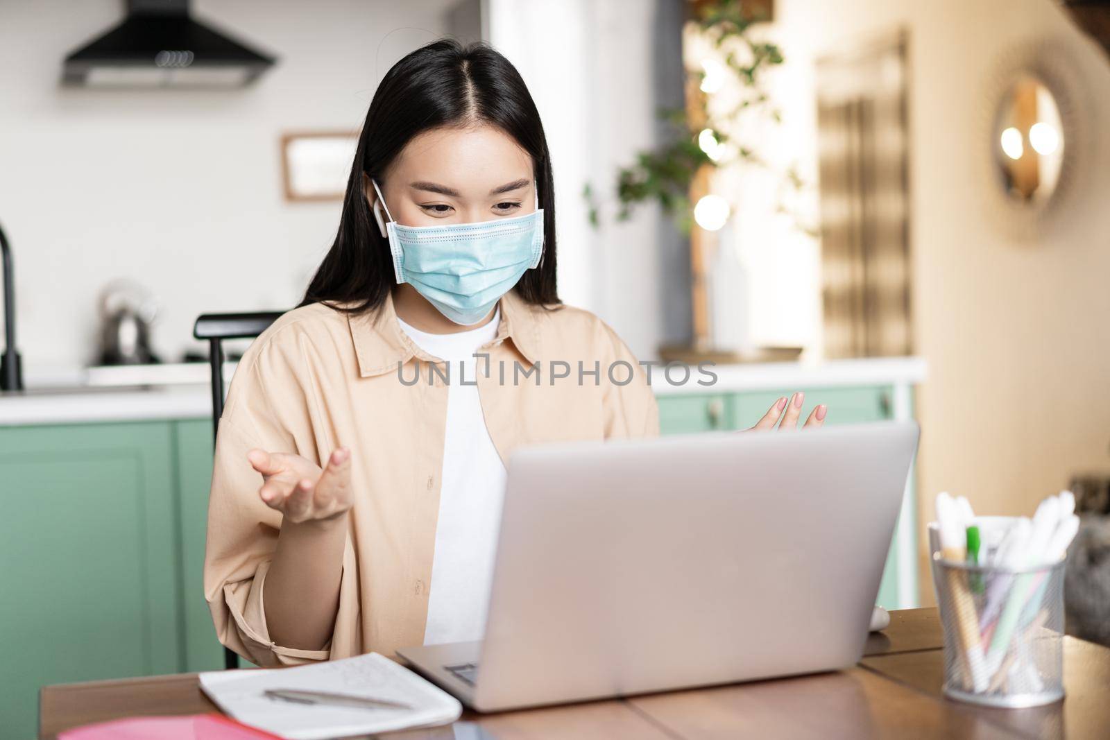 Young asian woman, student talking on video conference, attend lecture in medical face mask, online studying while on quarantine by Benzoix