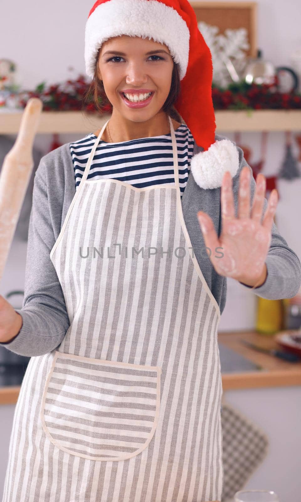 Christmas baking santa woman smiling happy having fun with Christmas preparations wearing Santa hat