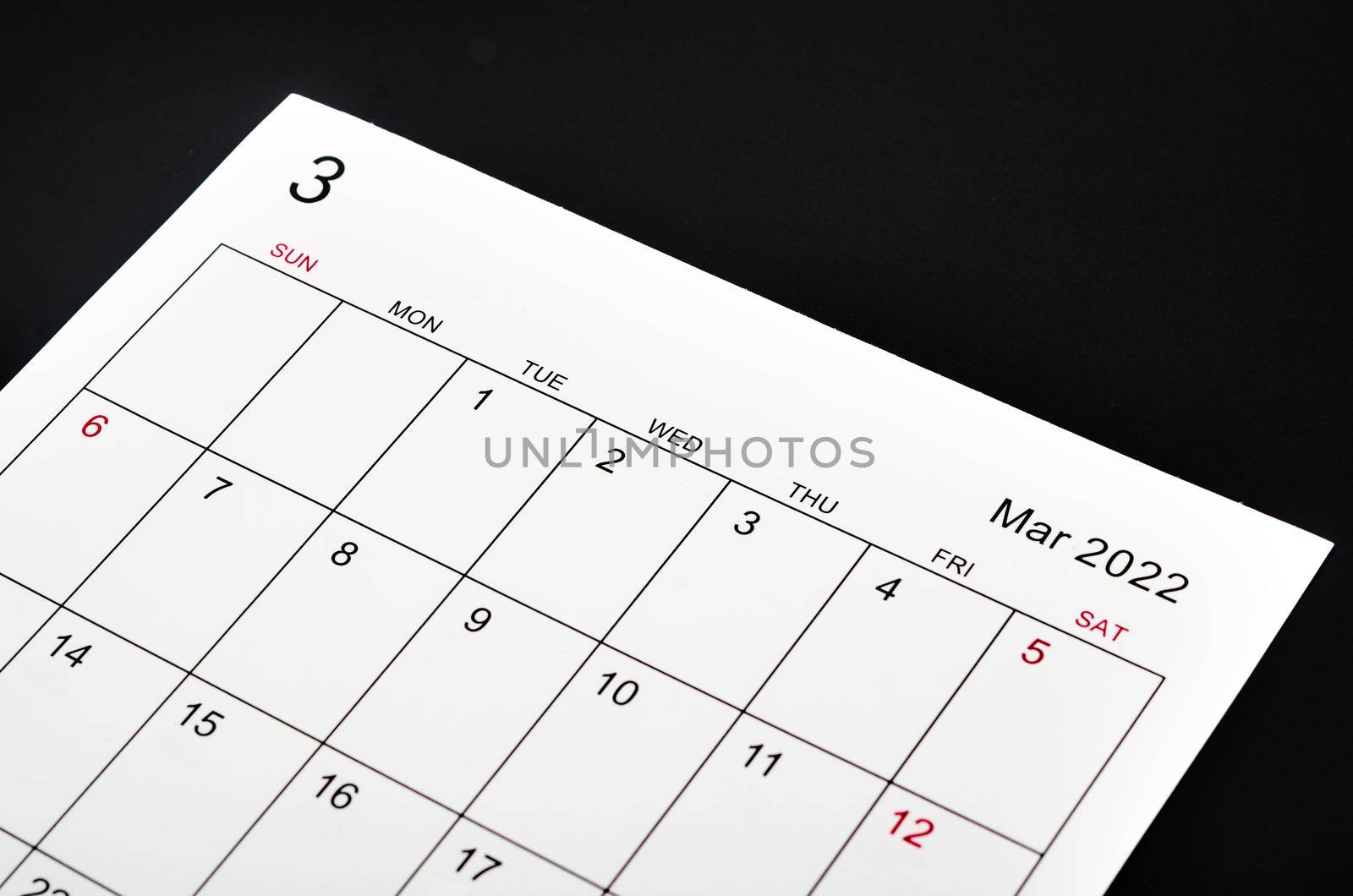 Close up March 2022 calendar sheet on black background.