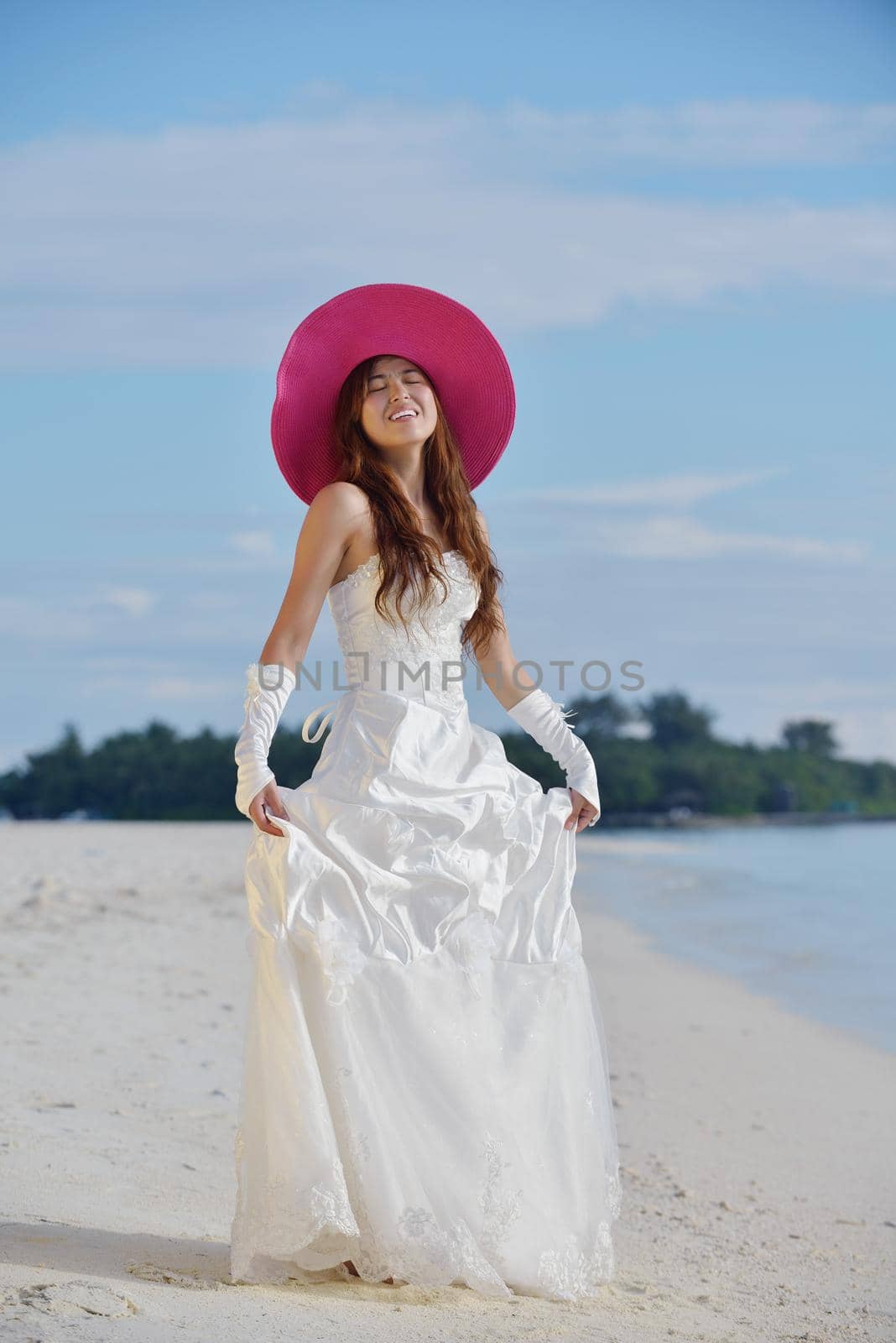 asian  bride with a veil on the beach in the sky and blue sea. honeymoon on the fantastic island at summer