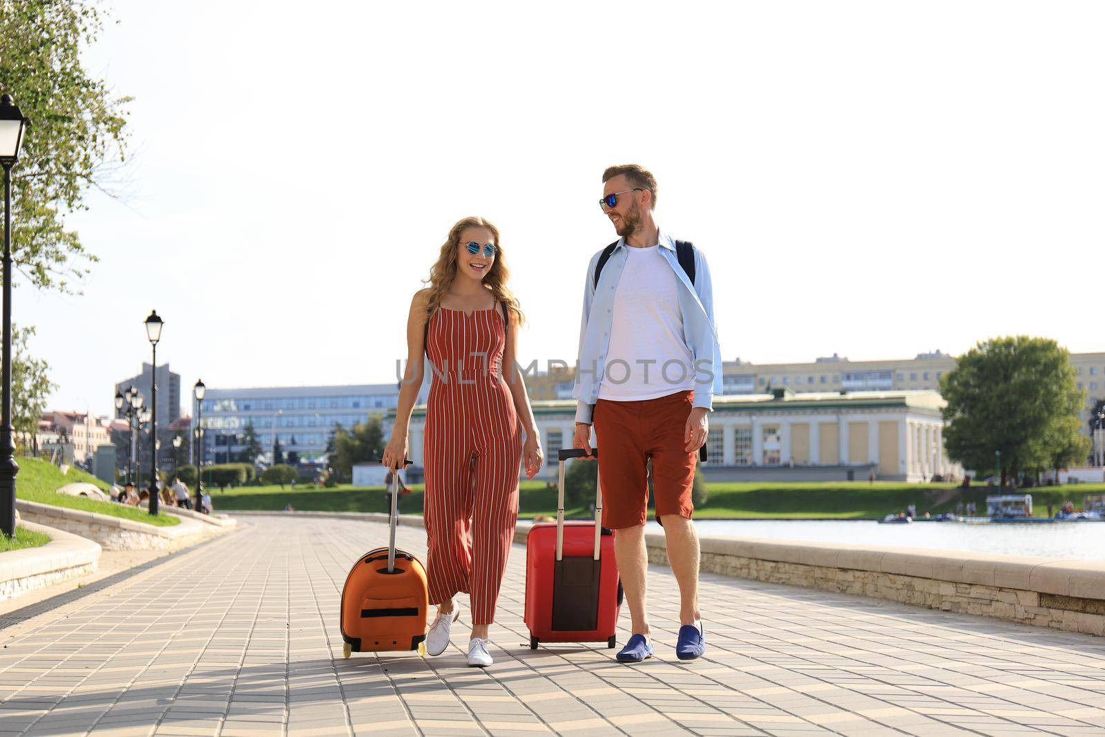 Summer holidays, tourism concept - smiling couple with luggage.