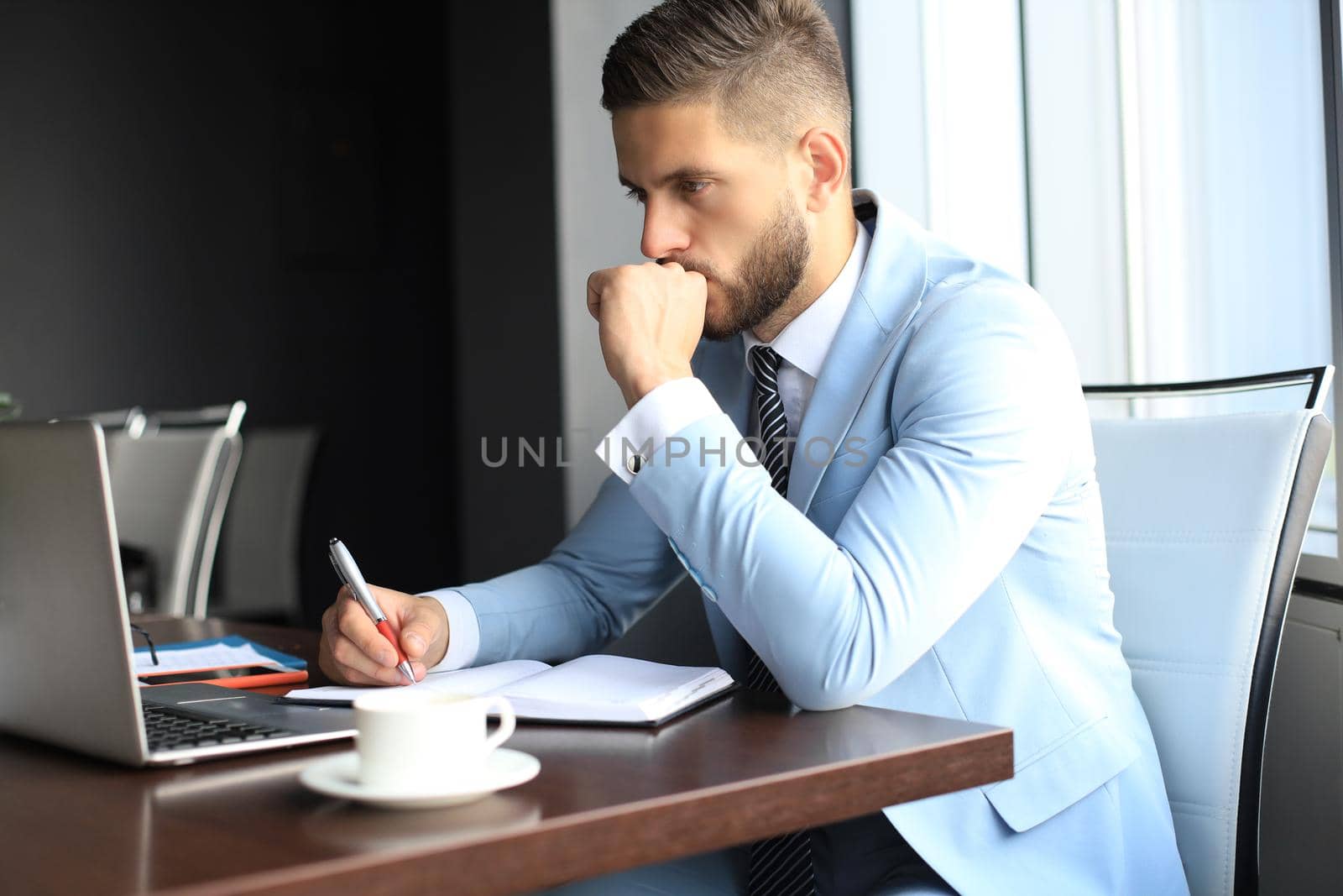 Modern businessman thinking about something while sitting in the office.