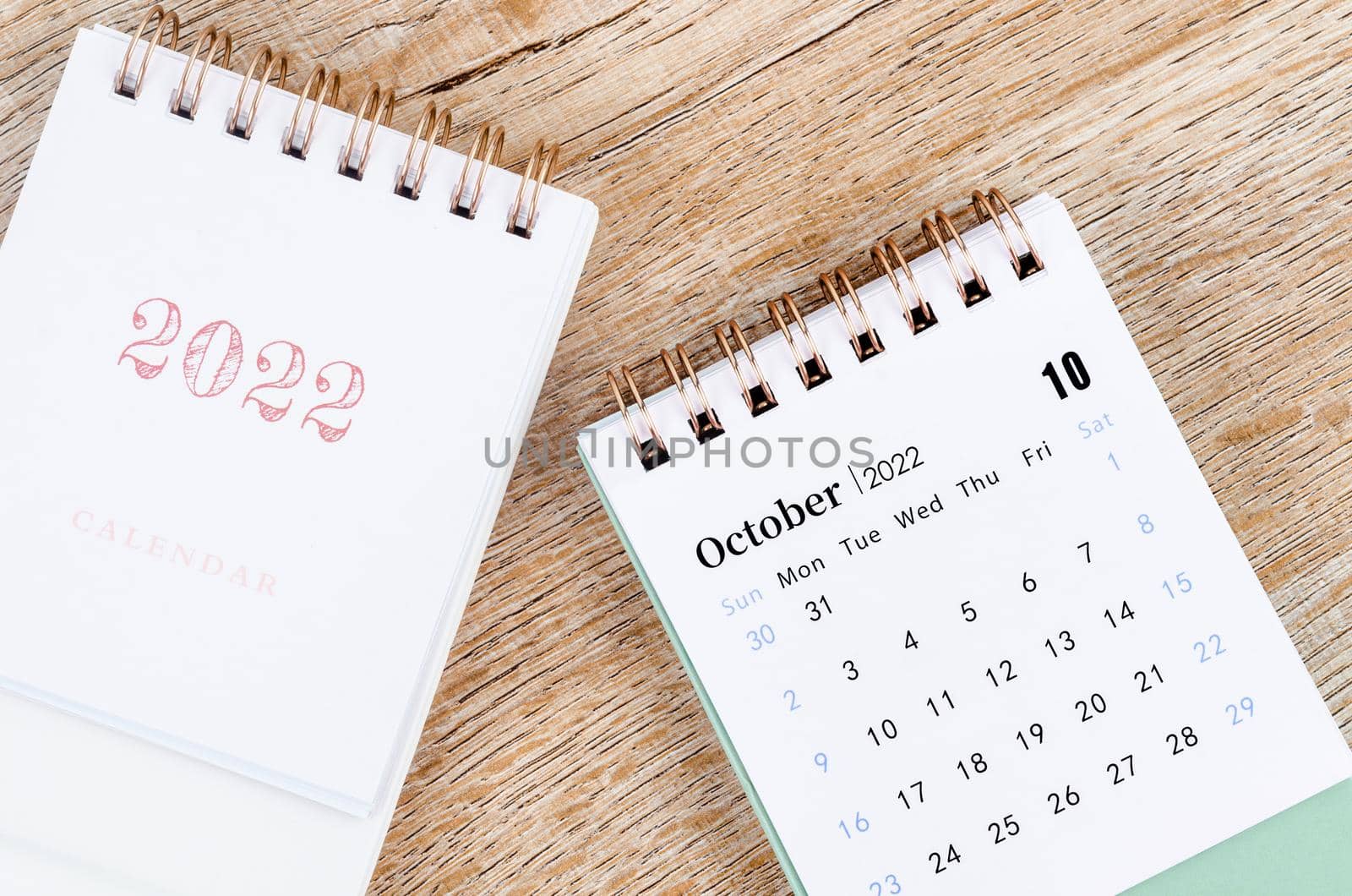 The October 2022 desk calendar on wooden table.