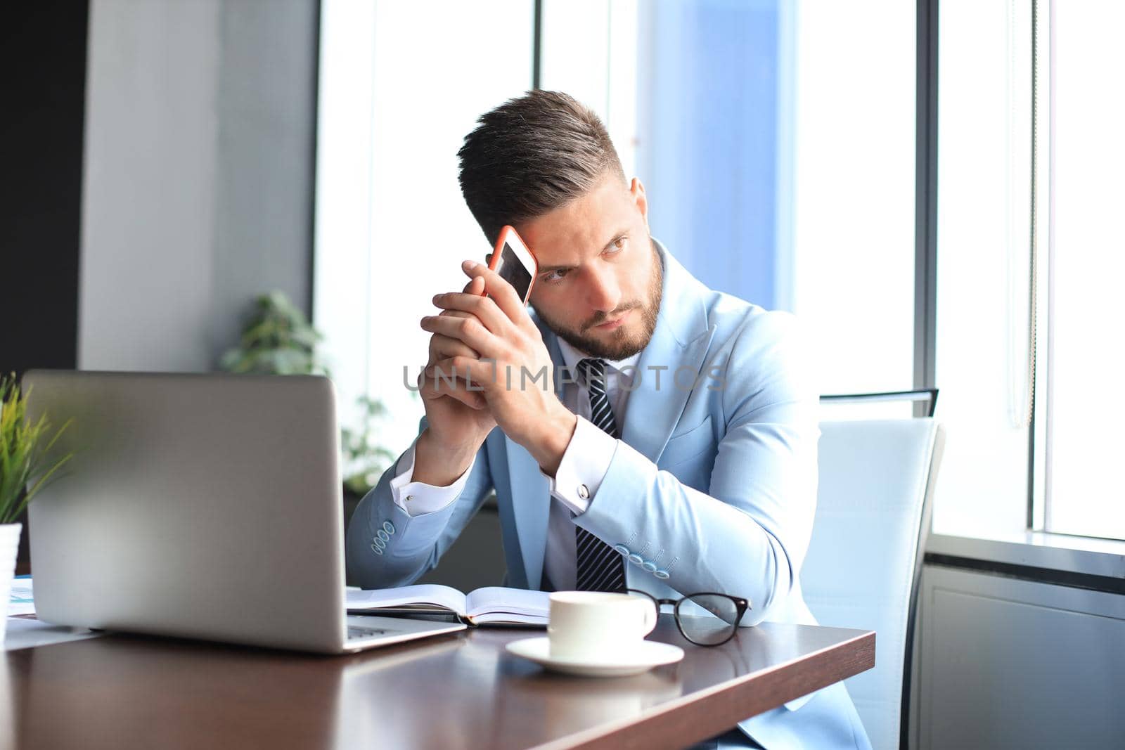 Modern businessman thinking about something while sitting in the office.