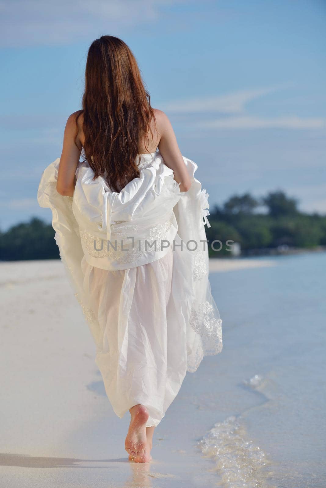 asian  bride with a veil on the beach in the sky and blue sea. honeymoon on the fantastic island at summer