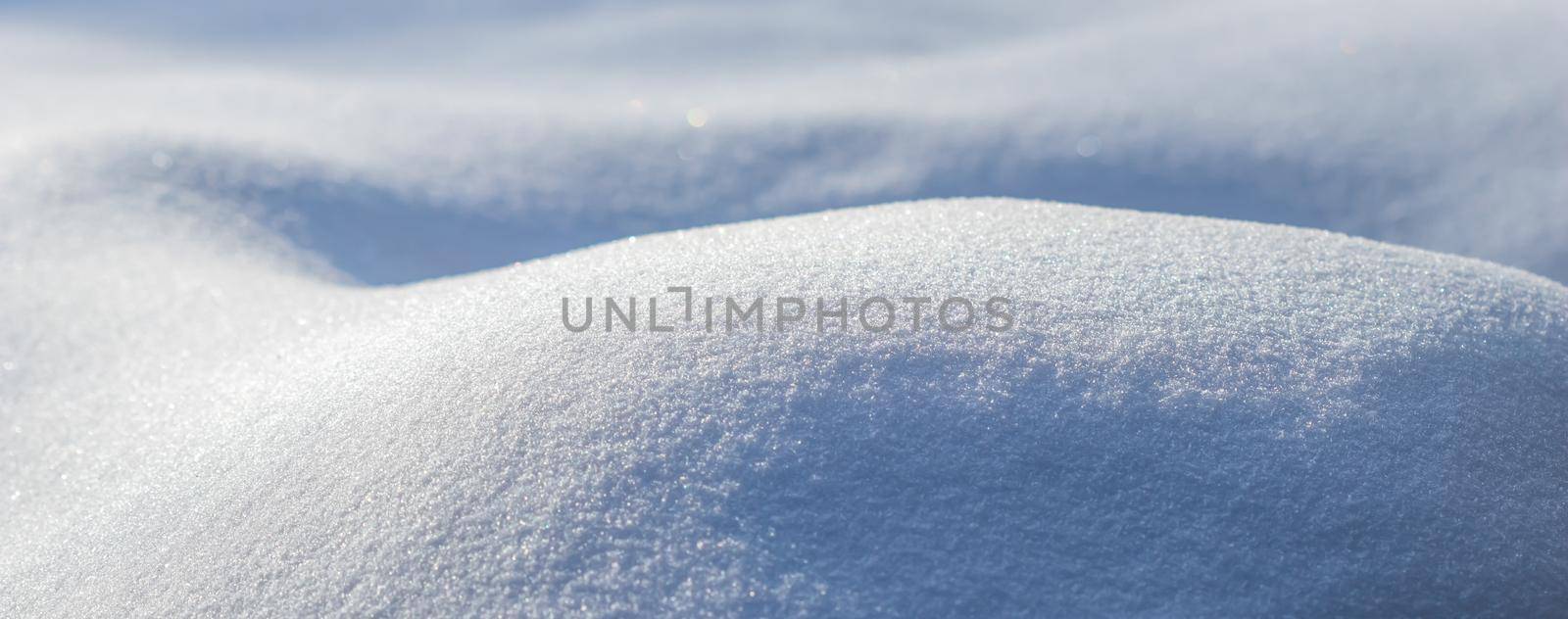 Drifts of fresh snow sparkling in the sun on a frosty day. Nature winter background.