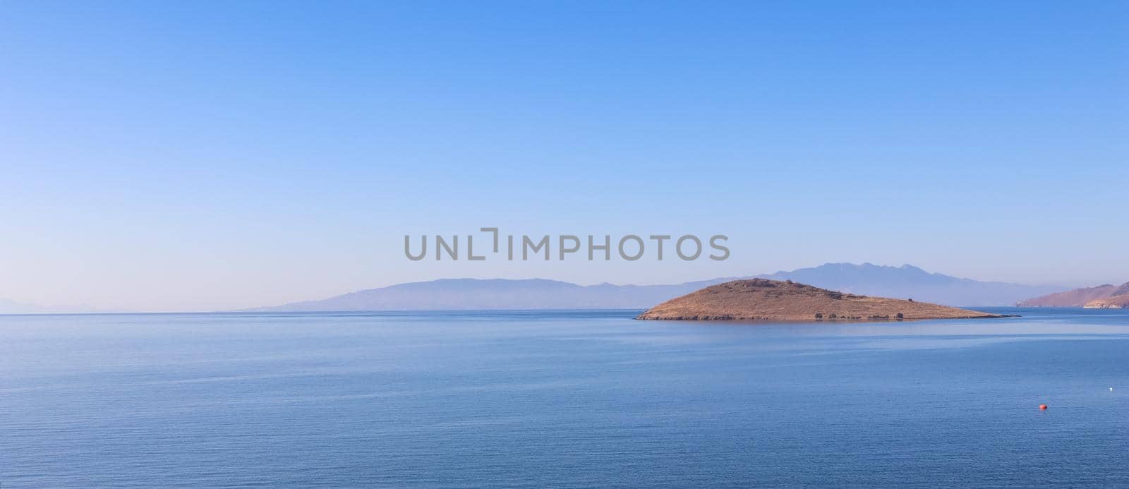 Aegean Sea with calm blue water and islands. Summer holiday concept and travel background
