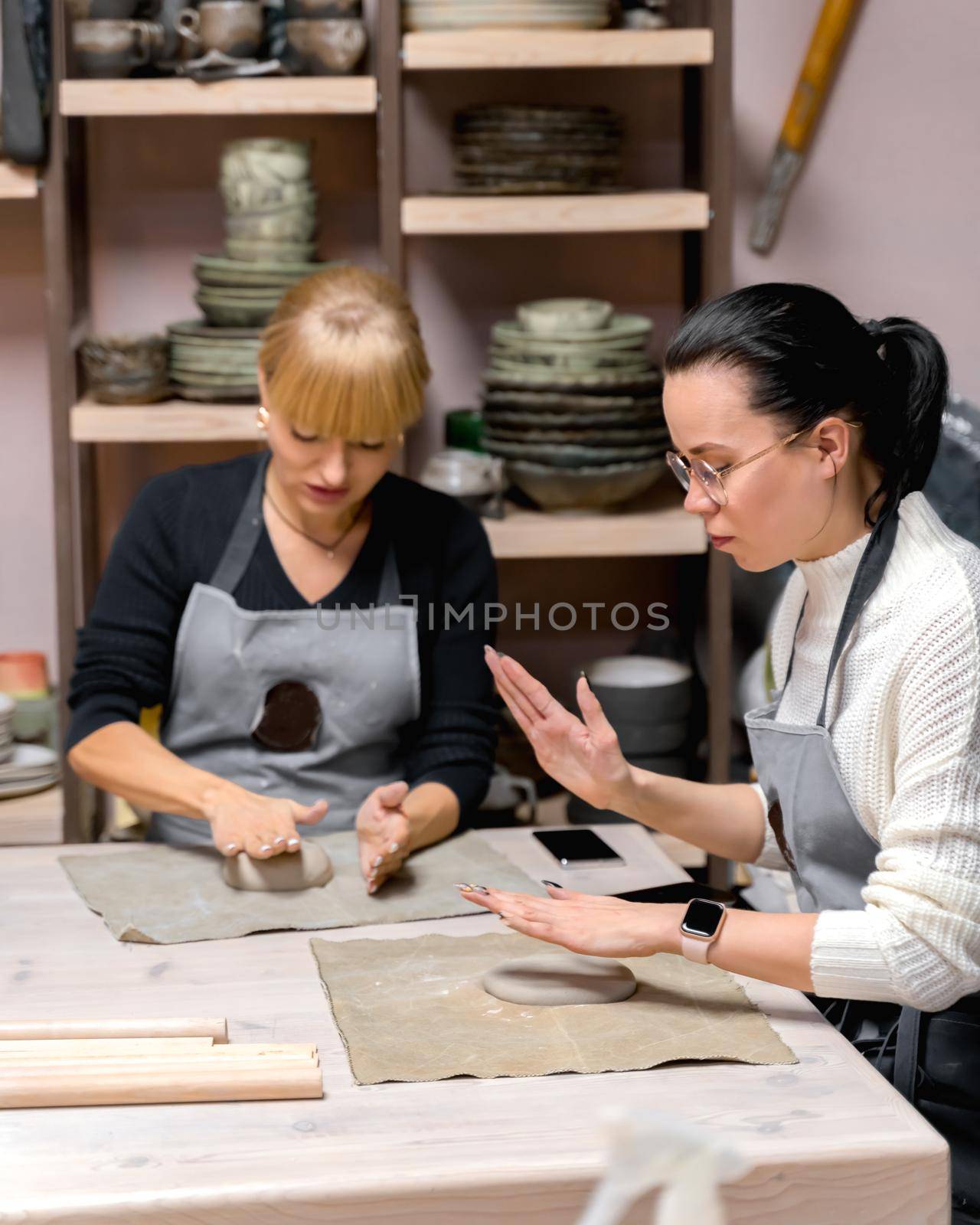 Woman making ceramic pottery on workshop. Concept for woman in freelance, business. Handcraft product. Earn extra money, side hustle, turning hobbies into to job. Selective focus, shallow depth