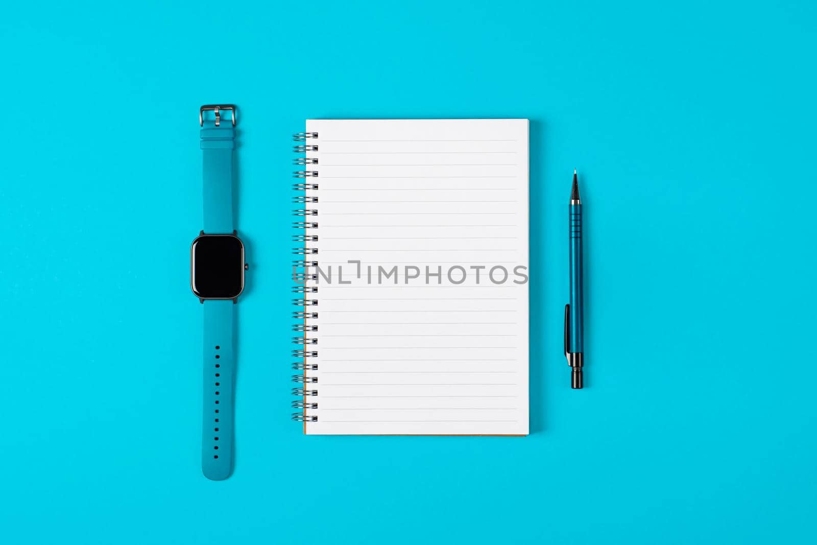 Notepad, watch, pen isolated on light blue background. Notepad with copy space. Office, business, discreet style