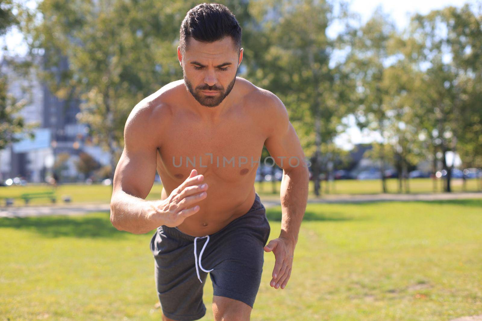 Athletic young man running in the nature. Concept of healthy lifestyle