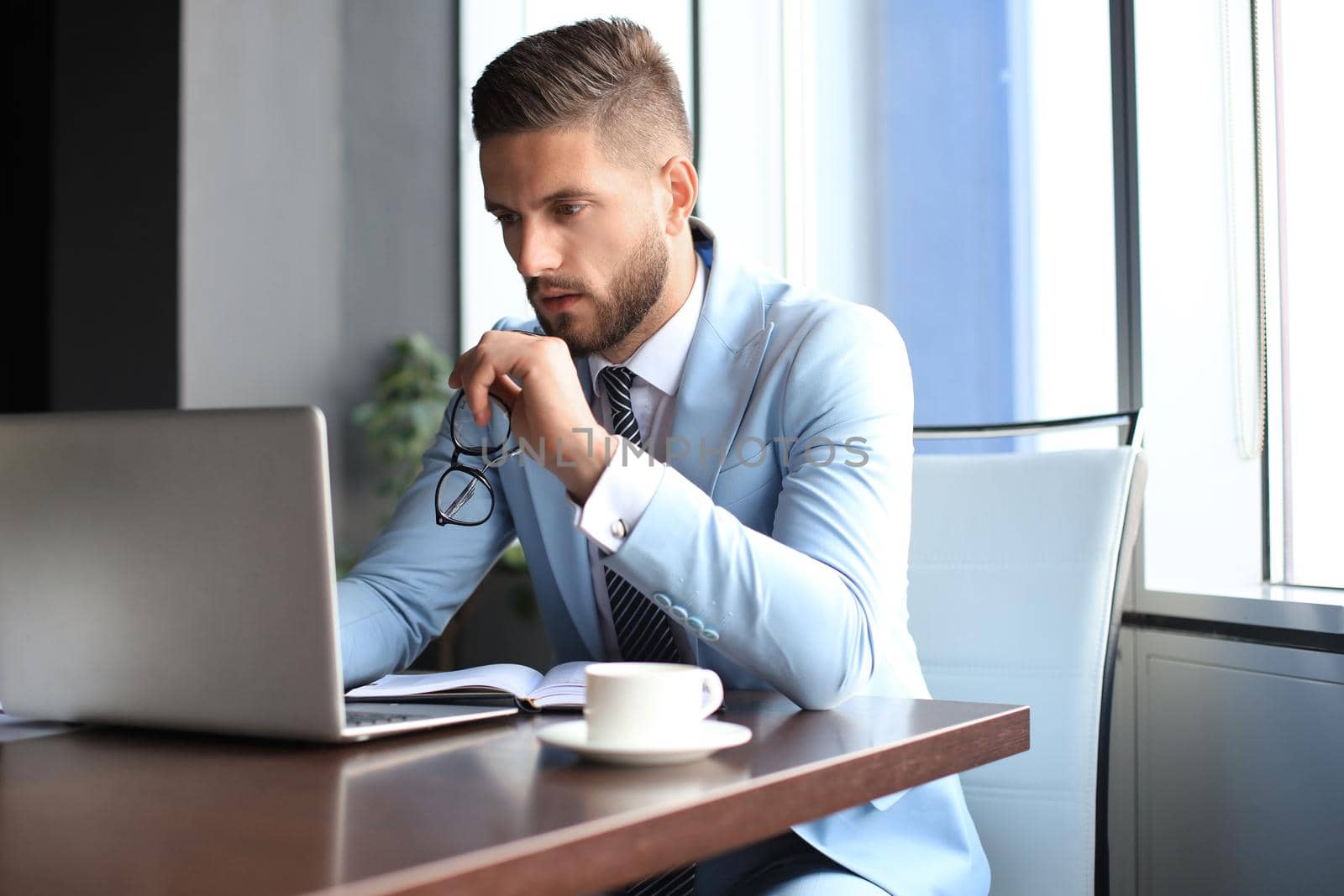 Modern businessman thinking about something while sitting in the office by tsyhun