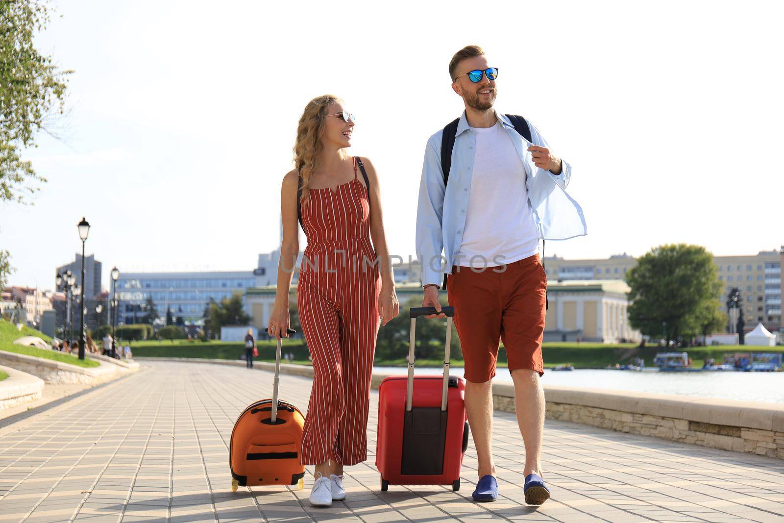 Summer holidays, tourism concept - smiling couple with luggage.