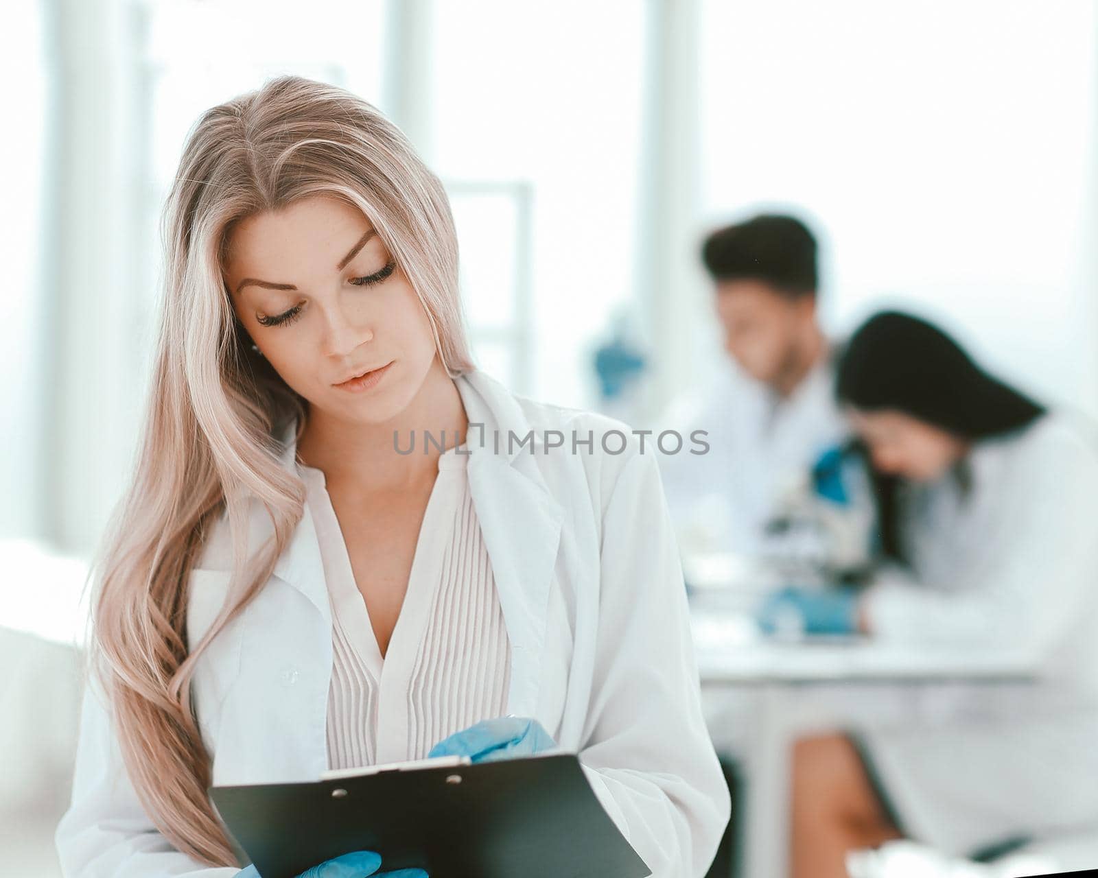 scientist make notes to the clipboard in the clinical laborator by SmartPhotoLab