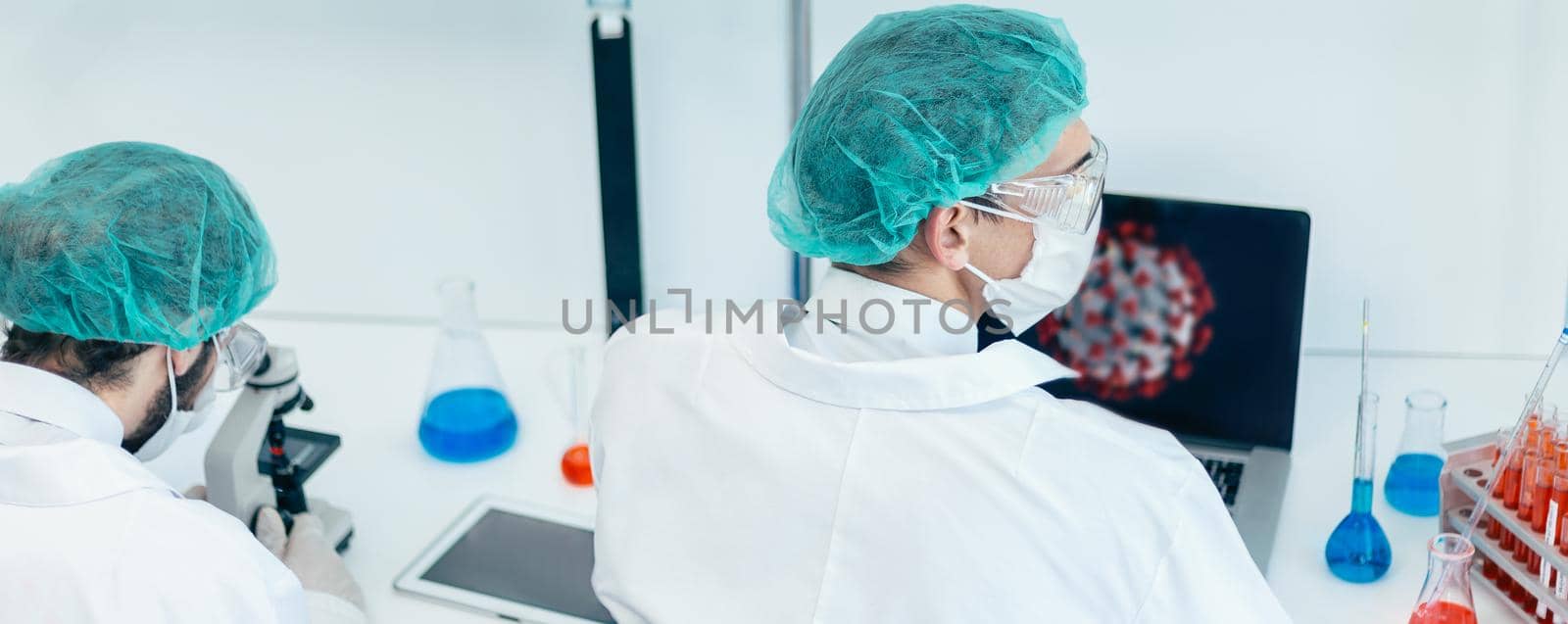 rear view. scientist sitting at a Desk in the laboratory. the concept of health care.