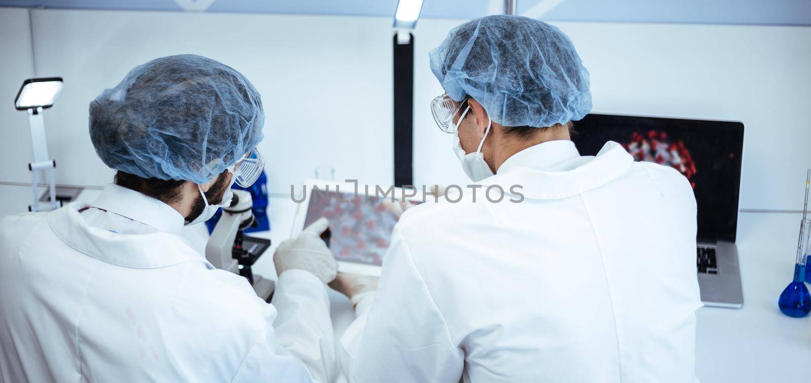 rear view. scientists discussing new information on the development of the virus. by SmartPhotoLab