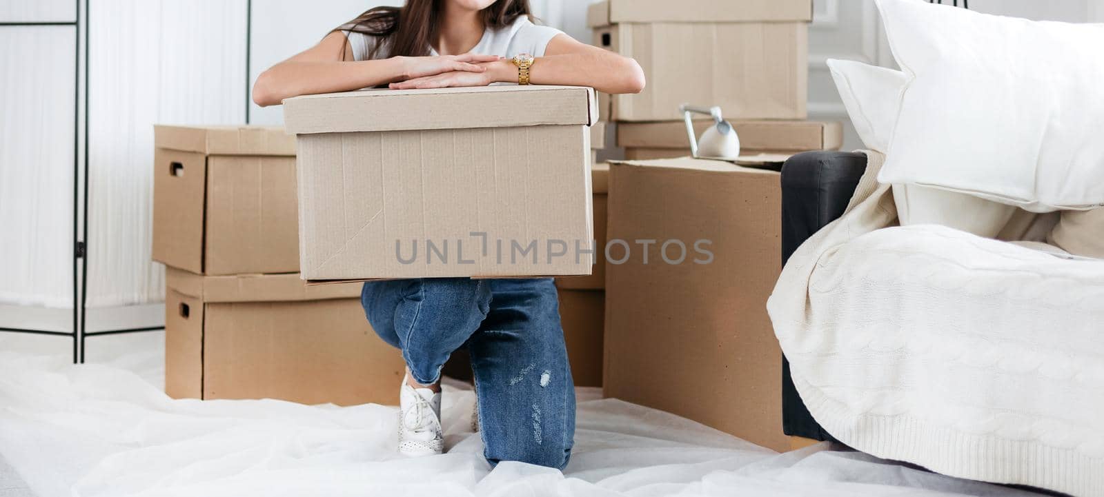 close up. young woman with a cardboard box sitting on the floor in a new apartment
