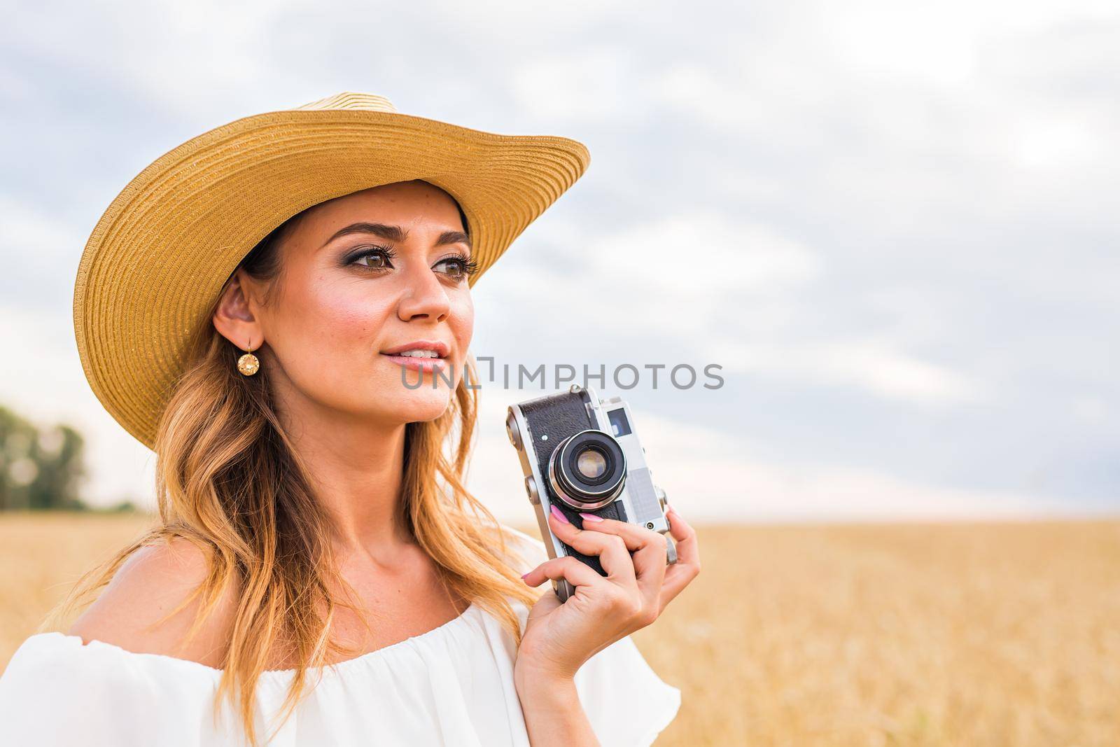 female photographer in the field with a camera taking pictures.