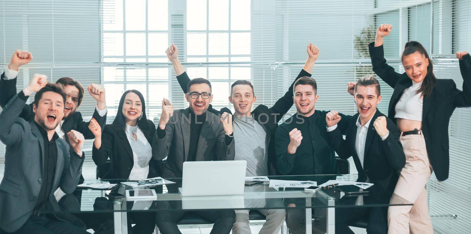 large business team showing their success while sitting at their Desk by SmartPhotoLab