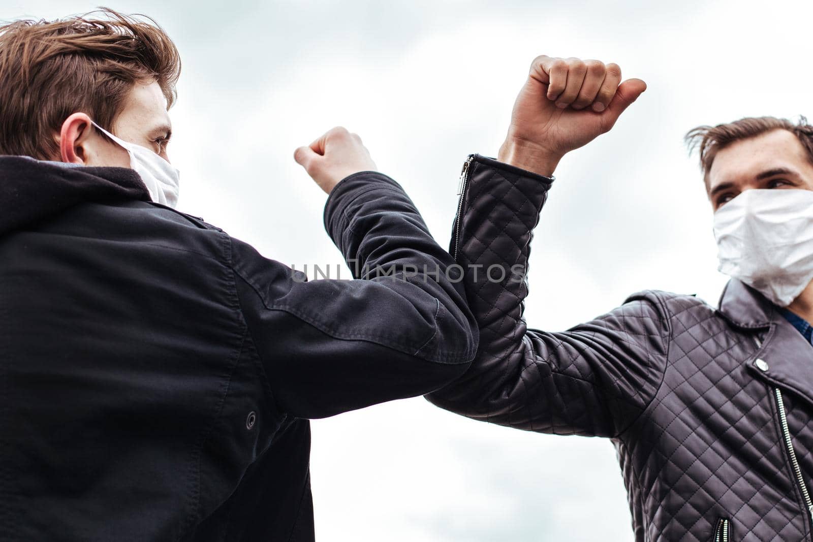 close up. friends in protective masks greeting each other. concept of health protection