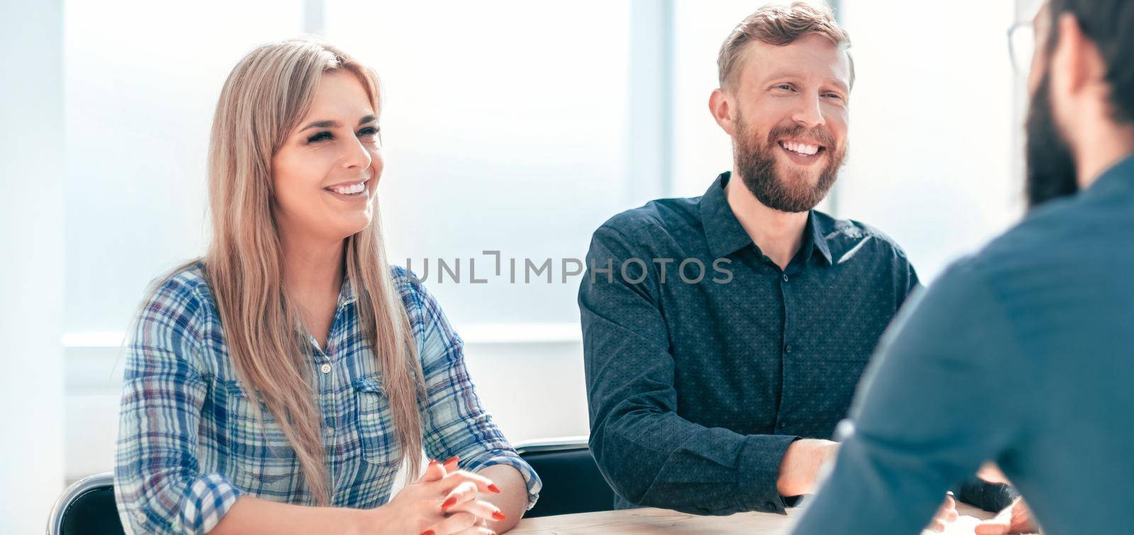 managers interview the applicant sitting at the office table. by SmartPhotoLab