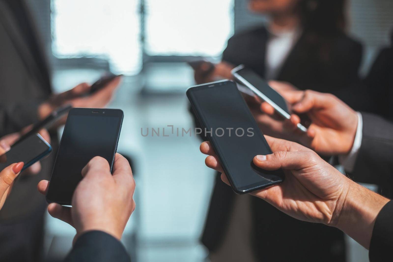 close up . young business people looking at their smartphone screens by SmartPhotoLab