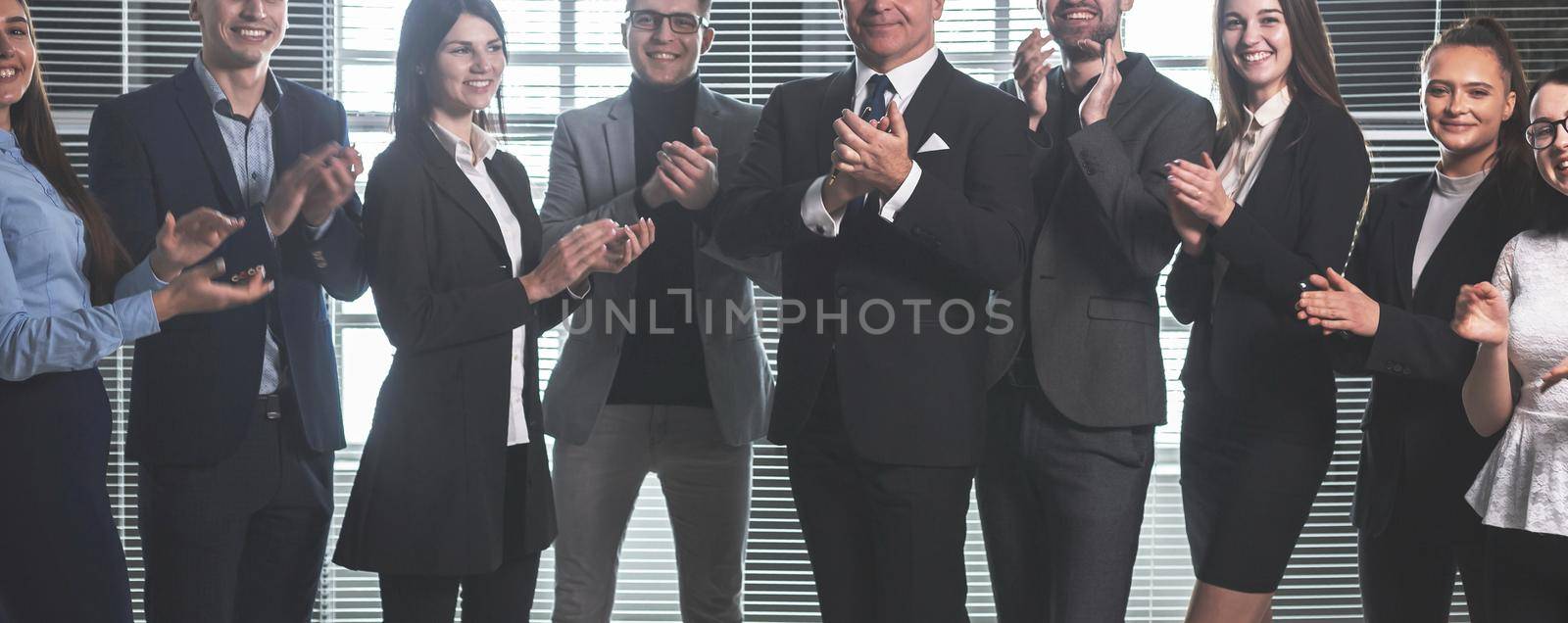 group of happy corporate employees applauding their success