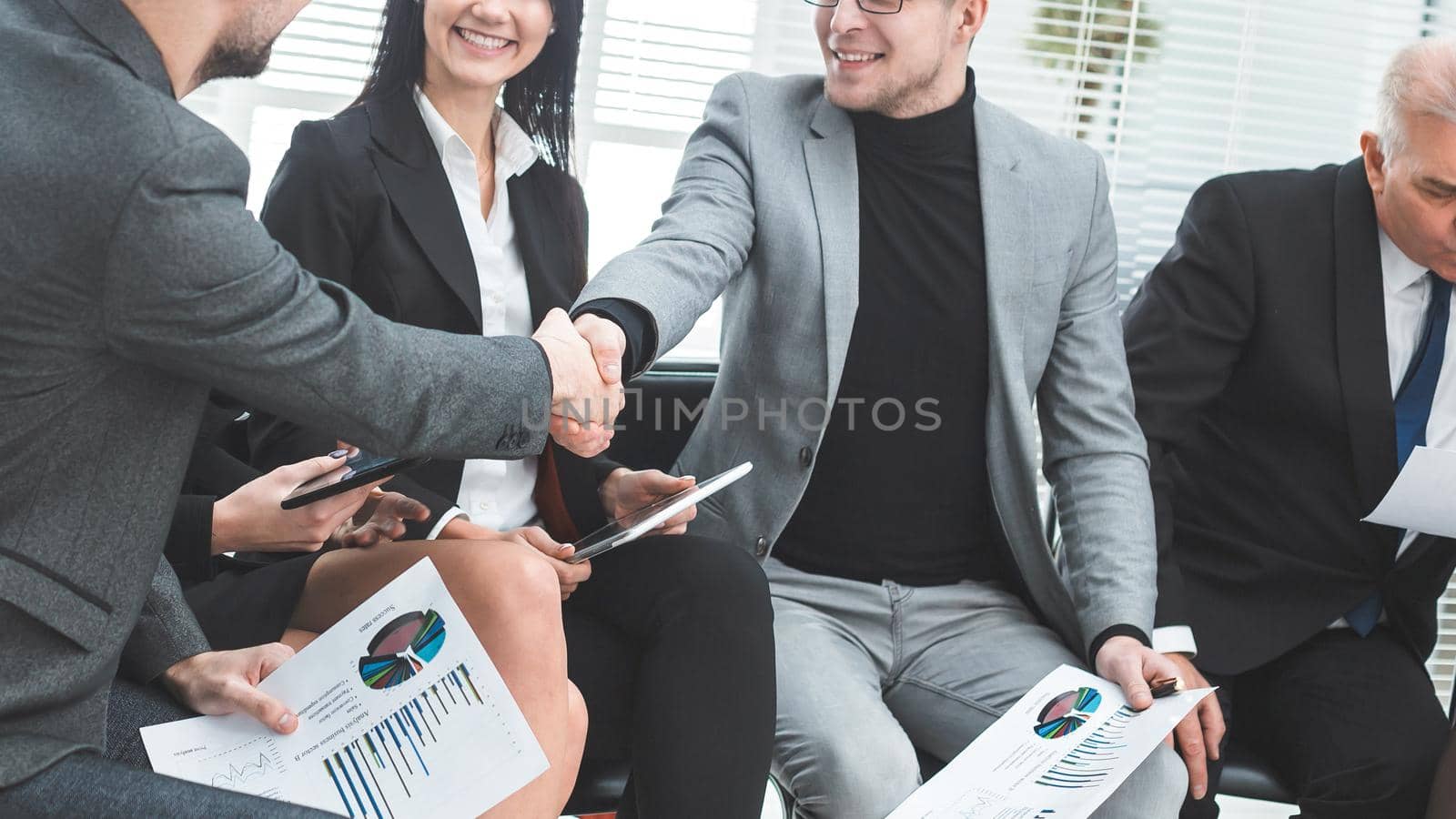 business colleagues shaking hands at an office meeting. by SmartPhotoLab