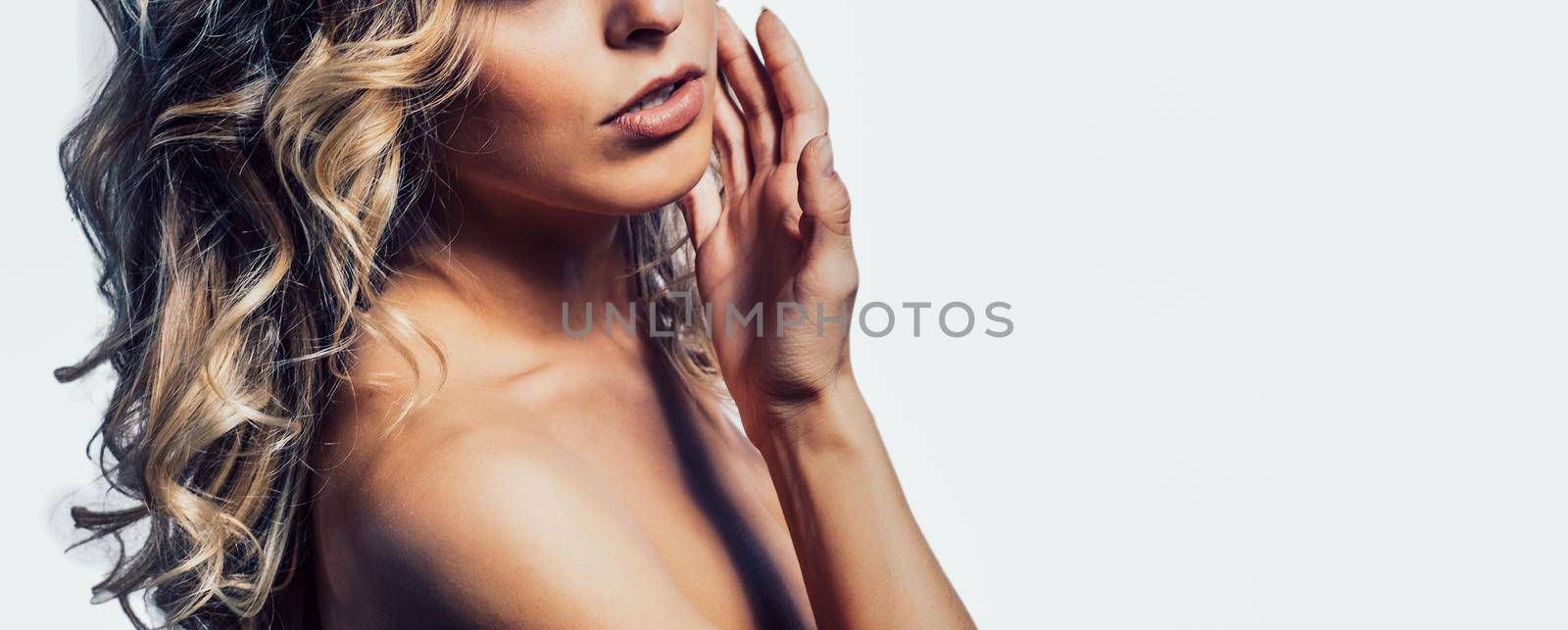 Beautiful girl model on a white background holding his hand to his face