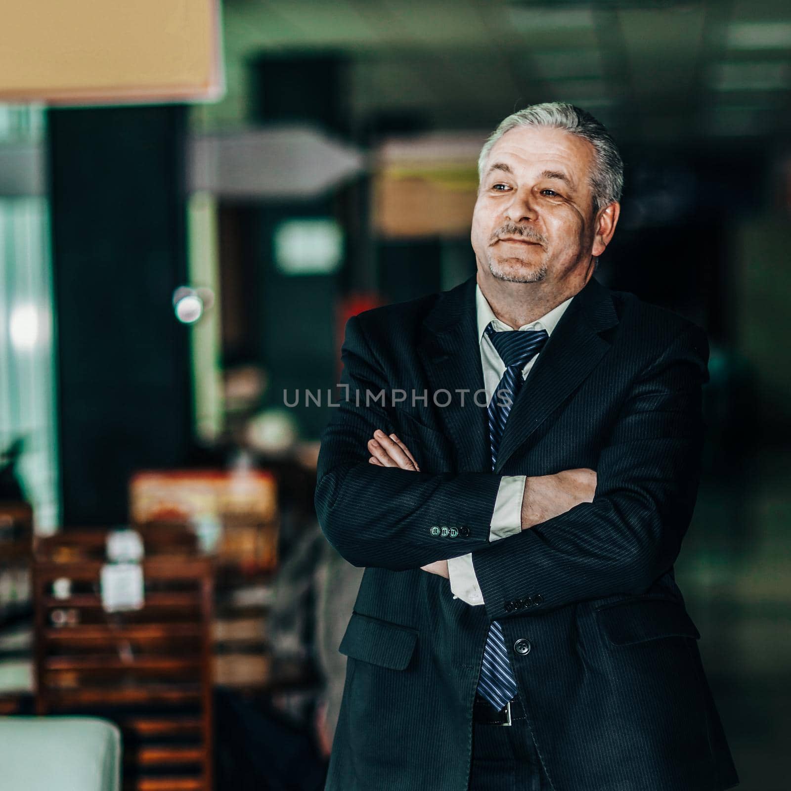successful businessman in a business suit on background of modern office