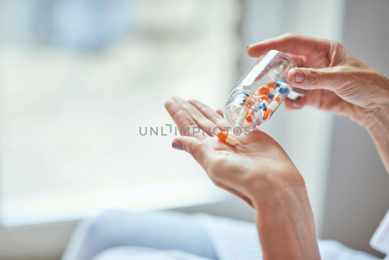 Woman getting wellness tablets from glass bottle on palm, close up view. Beauty and cosmetology concept