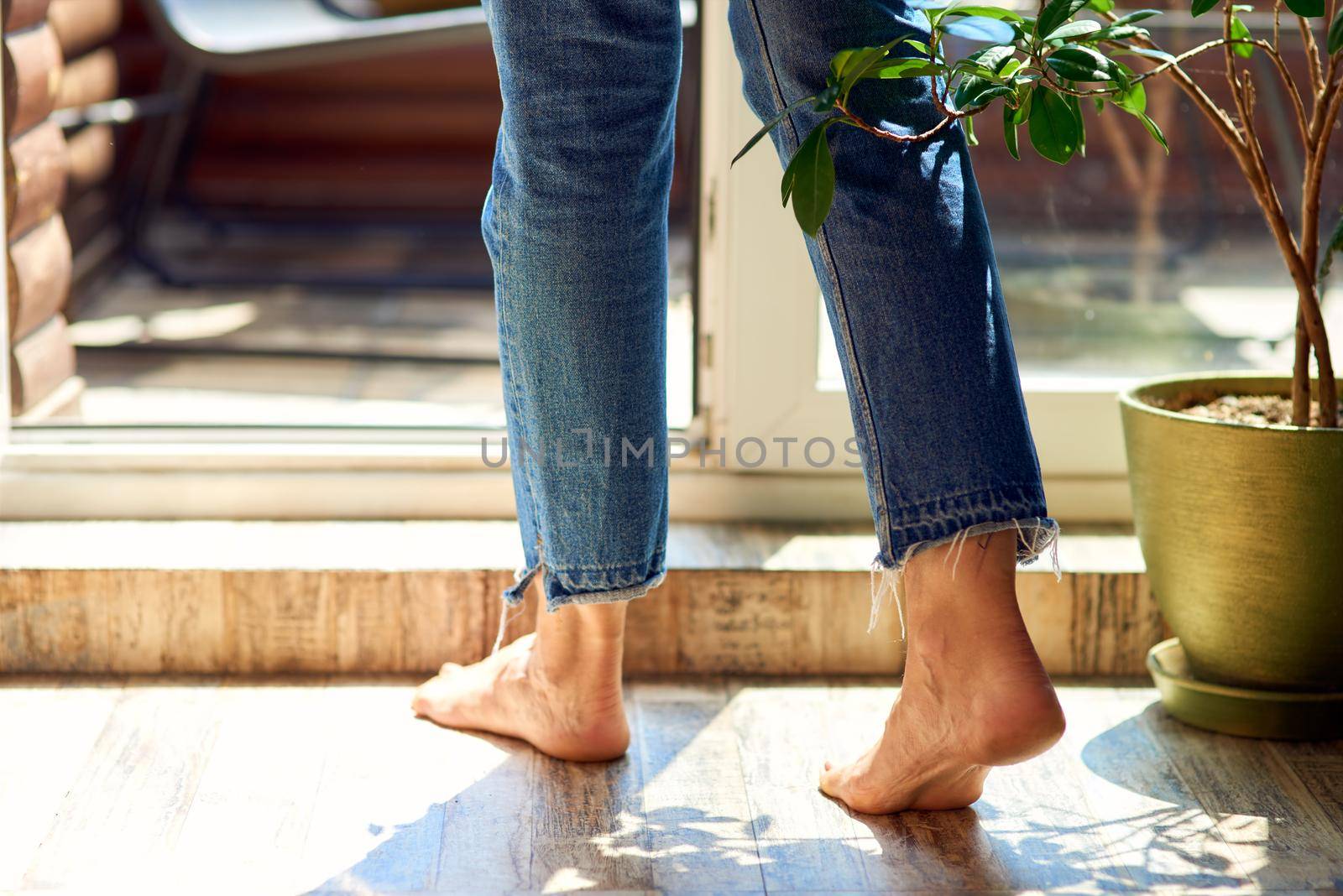 Bare feet of woman going out on terrace by friendsstock
