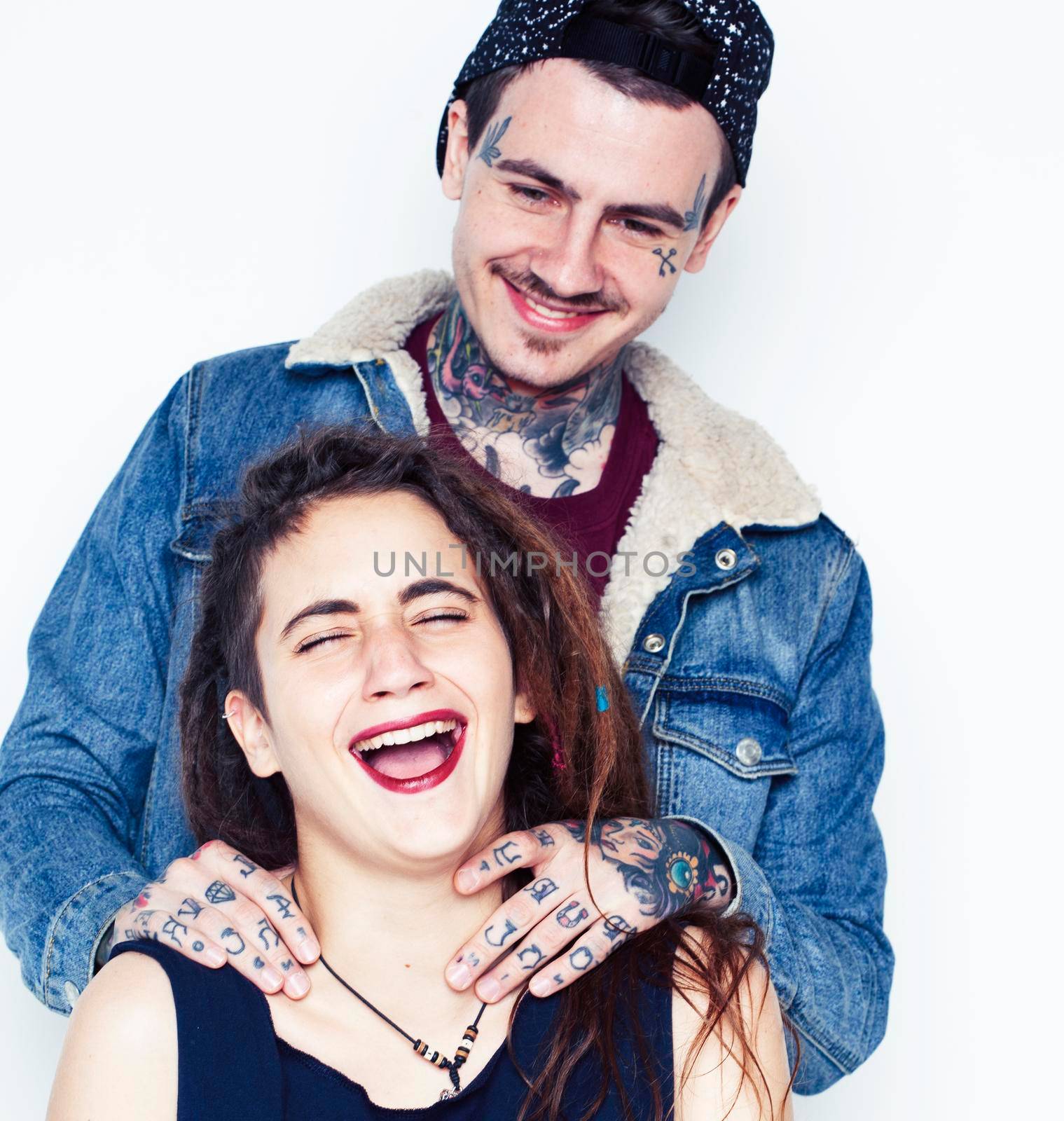 Young couple together. guy with tattoo, girlfriend wearing dreadlocks having fun on white background by JordanJ