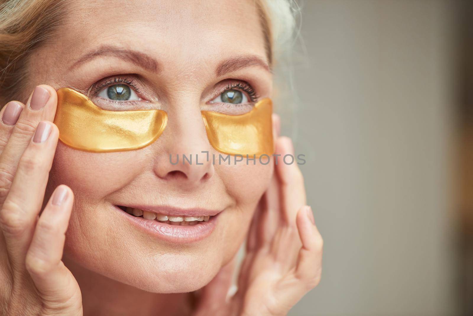 Happy middle aged caucasian woman with under eye patches by friendsstock