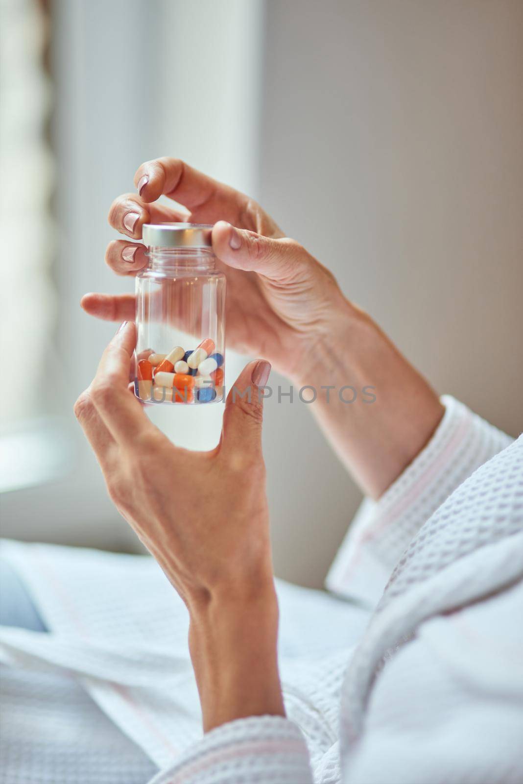 Beautiful female hands holding bottle with vitamins for wellness and skincare. Beauty and cosmetology concept