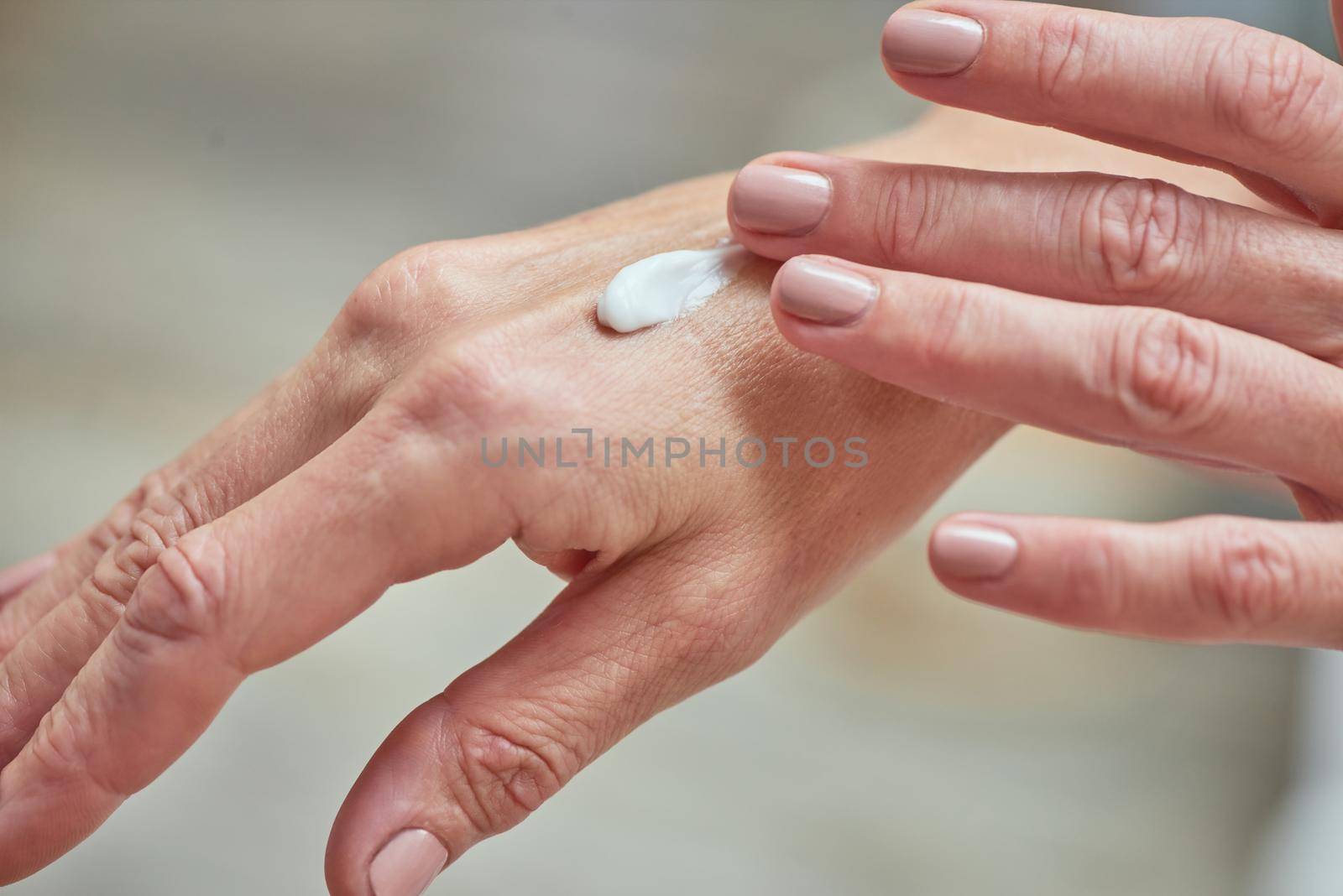 Middle aged woman hands applying cream by friendsstock